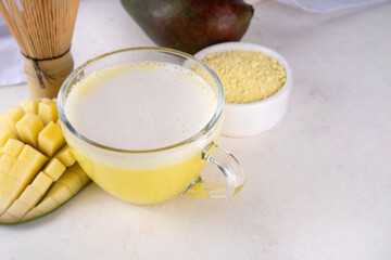 Yellow matcha drink. Mango matcha extract tea or latte, fruity healthy beverage on white background copy space