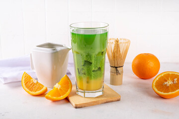 Orange Matcha Lemonade, Cold asia fruit cocktail with green matcha and orange citrus drink on white background, copy space