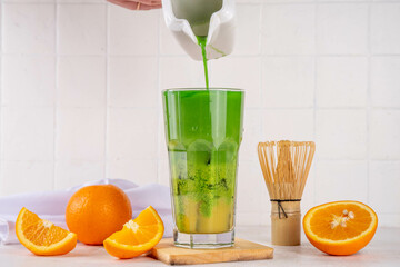 Orange Matcha Lemonade, Cold asia fruit cocktail with green matcha and orange citrus drink on white...