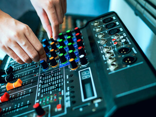 Close-up of sound engineer hands adjusting control sound mixer in recording, broadcasting...