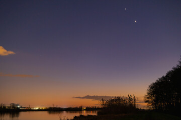 Jupiter and Saturn planets in the night sky appearing as a rare phenomenon at dusk during winter. The Great Conjunction an amazing and historical astronomical event at the end of day in Holland