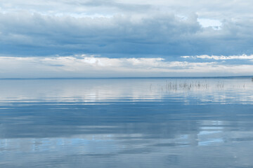 Nature picturesque landscape, clouds reflected on water surface, windless summer weather, tranquil blue trend sky background, mirroring sky on water, white blue nature gradient, aesthetic