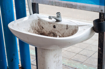 grungy and broken sink in a public place