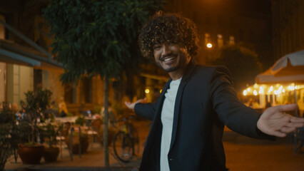 Handsome Indian Arabian Latino man pointing finger at camera beckon invitation gesture hand sign greeting motivation ethnicity posing positive cheerful guy offer welcome call come here city outdoors