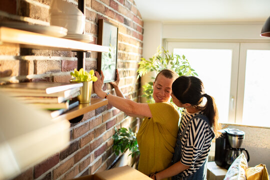 Affectionate lesbian couple enjoying time together while unpacking in new home