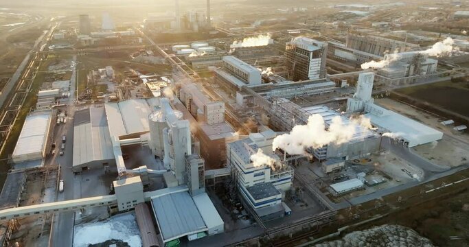 Iindustrial chemical plant with high pipes in bright light of winter sunset aerial view. SOLVEY SODI JSC Devnya, Bulgaria Synthetic soda ash production plant. Thick smoke comes from high pipe. Ecology