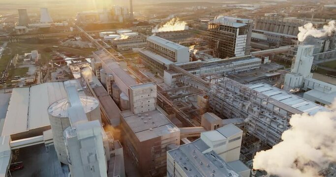 Iindustrial chemical plant with high pipes in bright light of winter sunset aerial view. SOLVEY SODI JSC Devnya, Bulgaria Synthetic soda ash production plant. Thick smoke comes from high pipe. Ecology