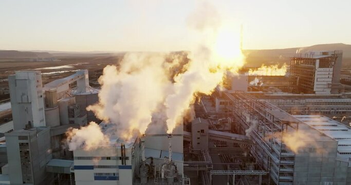 Iindustrial chemical plant with high pipes in bright light of winter sunset aerial view. SOLVEY SODI JSC Devnya, Bulgaria Synthetic soda ash production plant. Thick smoke comes from high pipe. Ecology