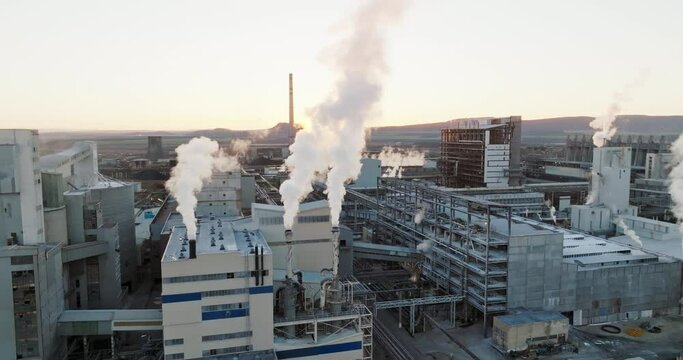 Iindustrial chemical plant with high pipes in bright light of winter sunset aerial view. SOLVEY SODI JSC Devnya, Bulgaria Synthetic soda ash production plant. Thick smoke comes from high pipe. Ecology