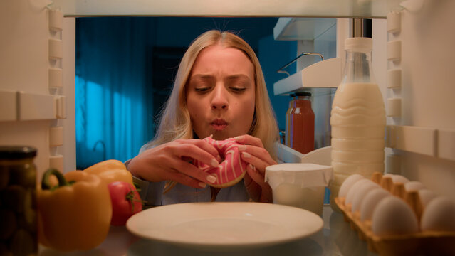 Point Of View POV From Inside Refrigerator Hungry Caucasian Woman Girl At Night Evening Kitchen Open Fridge Take Out Eating Sweet Donut Unhealthy Nutrition Obesity Diet Failure Overeating Food Addict