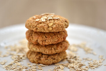 Oatmeal cookies with oat flakes on a white plate. Healthy food for breakfast or a snack. Side view. Soft focus - 755642763