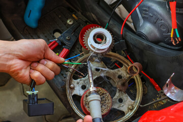 selective focus wires in the hand of a car mechanic Practicing repairs to the ATV's electrical system. Wires of various colors help you know the direction of your car's electrical system.