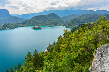 Fototapeta na wymiar Cloudy summer day by the lake Bled in Slovenia with its clear turquoise water and famous castle and church