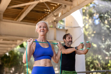 Obraz premium older couple doing sports and stretching with elastic bands