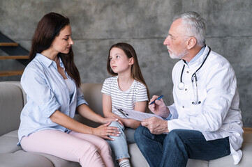Doctor with medical documents talking with mom of child patient