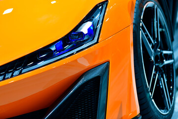 Front view headlights of orange sport car 