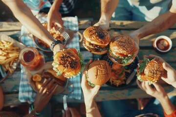 group of people eating hamburger on the grill outdoors