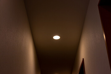 薄暗い通路を照らす天井の小さなダウンライト