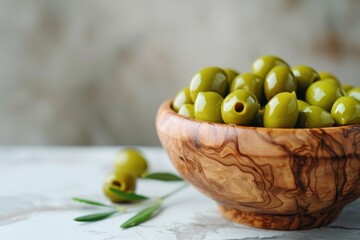 Bowl of Fresh Green Olives on a Marble Counter Against a Softly Marbled Background