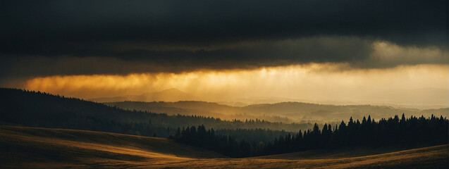 Golden Light Streaming Through Clouds Over a Hilly Landscape at Dusk - obrazy, fototapety, plakaty