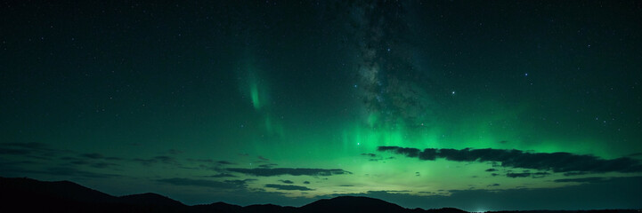 Fototapeta na wymiar Glowing Green Aurora Bore in Night Sky