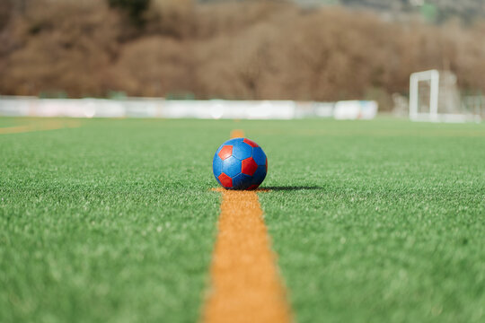 Soccer ball on the grass at the midfield line