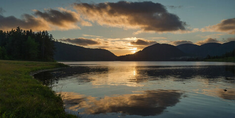 Sun Setting Over Lake With Mountains
