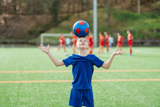 Young soccer player balancing ball on forehead