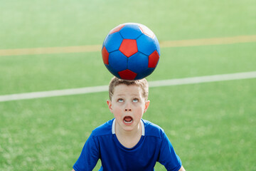 Young soccer player balancing ball on head