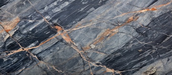 A detailed view of a smooth, shiny black marble surface, showcasing its unique veining and texture under the light. The surface reflects a sleek and polished appearance.