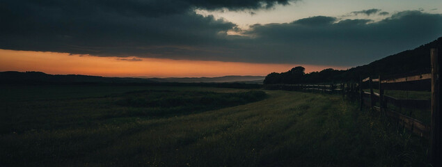 Serene Dusk Setting Over a Rolling Countryside Landscape With Dramatic Sky