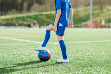 Young soccer player ready to kick the ball on field