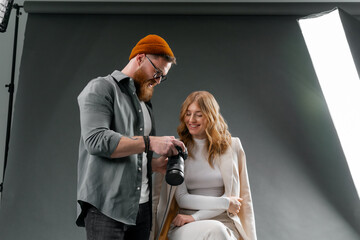 Man captures woman in chair at event, exhibiting fashion design and fun gesture