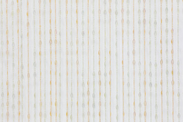 Fragment of crystal curtain of plastic beads near white wall in studio