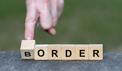 Hand turns wooden cube and changes the word border to order. Symbol for strict border control. - obrazy, fototapety, plakaty