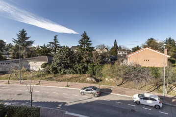 Curve on a one-way street in an urbanization of single-family homes with garden areas and large...