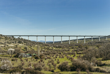 A road bridge over a valley with sparse vegetation