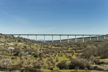 Fototapete Landwasserviadukt A road bridge over a valley with sparse vegetation