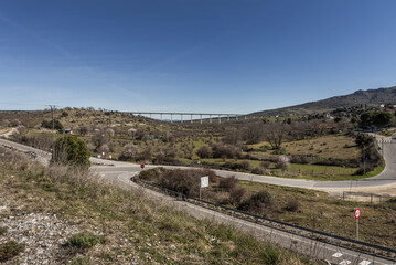 mountain roads and a bridge crossing a valley with sparse vegetation
