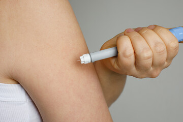 Self injection pen in female hand. Medicine and treatment concept
