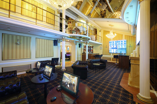 Empty bar, tables with computers for playing and screens in luxury bookmaker office of casino