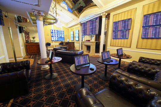 Tables with gaming computers and lot of screens in bookmaker office of casino, my photo on screens