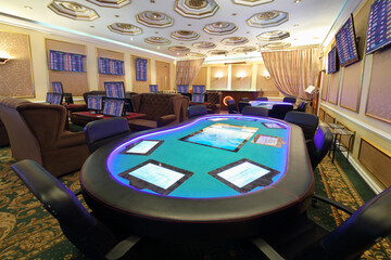 Empty casino with modern electronic poker table and electronic gaming machines, my photo on screens