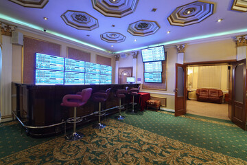 Empty wooden counter and lot of screens in luxury bookmaker office with carpet, my photo in frame