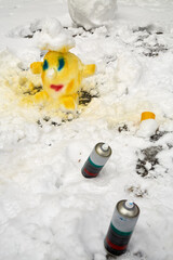 Obraz premium Head made of snow and painted by spray and two cans near