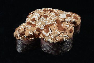 Colomba pasquale or Easter Dove is a traditional Italian dessert prepared with sourdough, almonds and candied fruit prepared during the Easter holidays. Front view on black background isolated