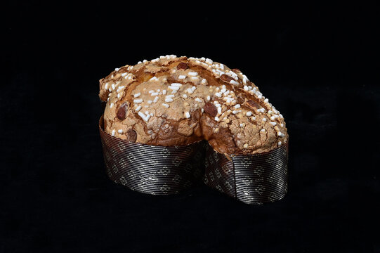 Colomba pasquale or Easter Dove is a traditional Italian dessert prepared with sourdough, almonds and candied fruit prepared during the Easter holidays. Front view on black background isolated