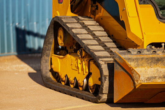 Industrial compact skid steer loader rubber tracks close up of construction equipment