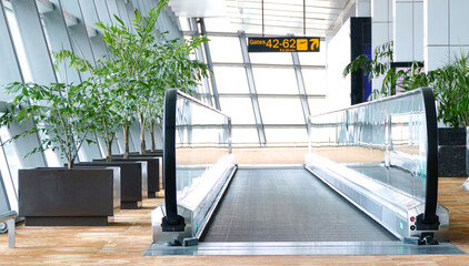 Modern horizontal moving walkway at international airport; travel the world concept