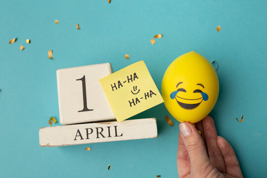 April 1st. Image of april 1 wooden calendar and festive decor on the blue background. April Fool's Day